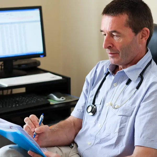 Huisarts met een stethoscoop aan zijn bureau